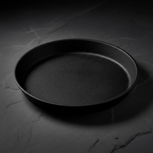 Cast iron pizza pan 30cm on dark slate surface